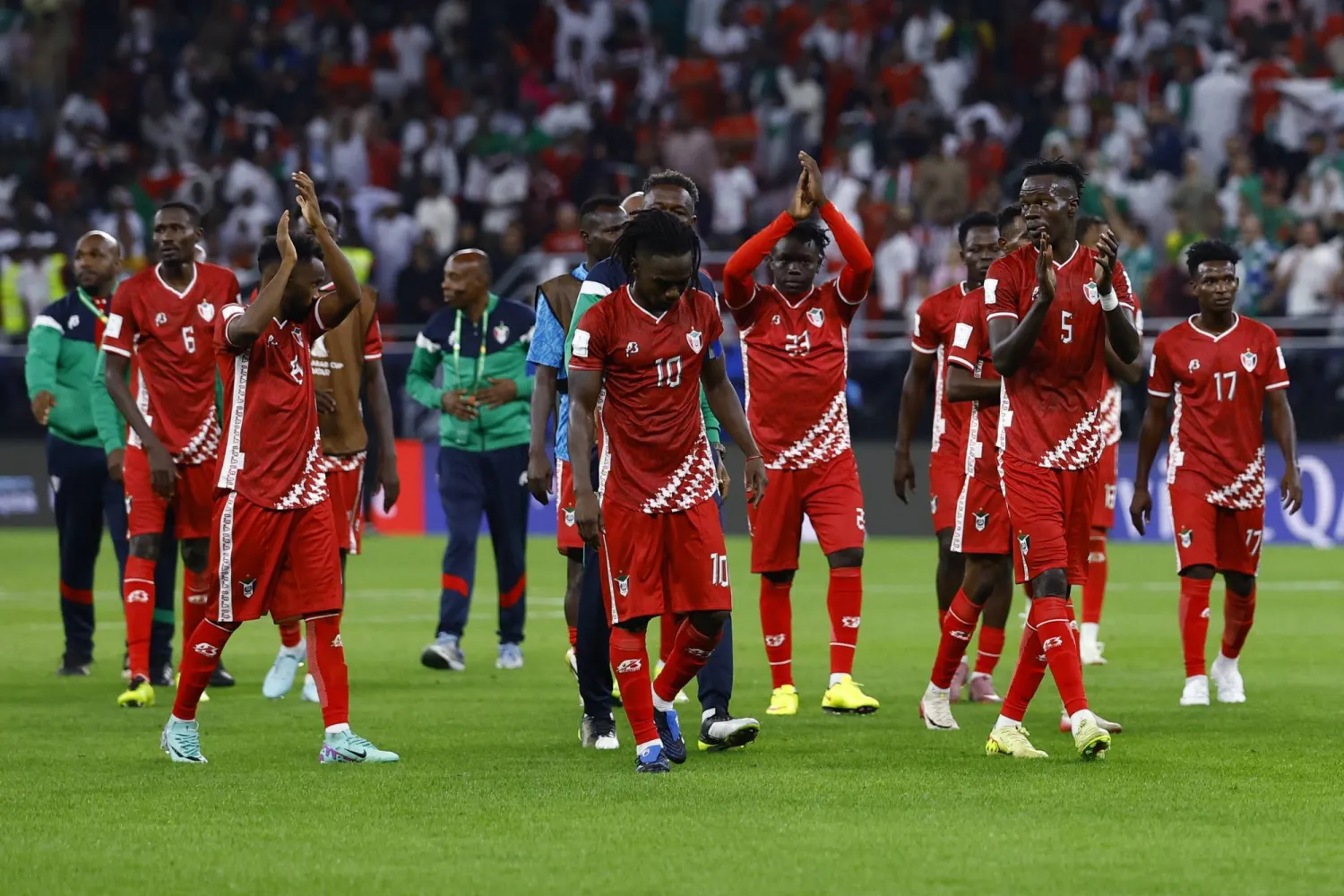 لاعبو السودان يحييون جماهيرهم بعد نهاية المباراة أمام الجزائر (رويترز)