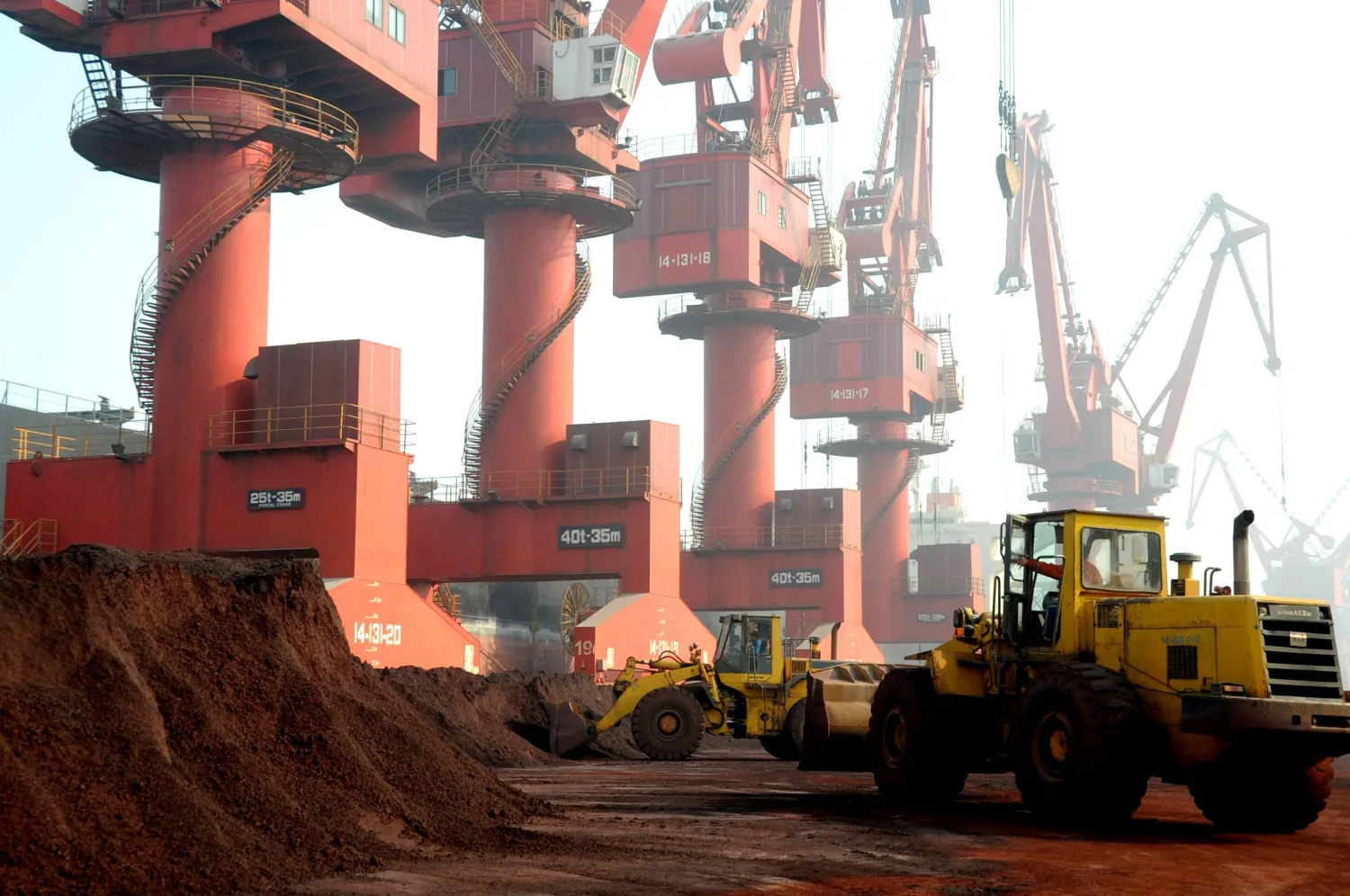 FILE PHOTO: Workers transport soil containing rare earth elements for export at a port in Lianyungang, Jiangsu province, China October 31, 2010. REUTERS/Stringer/File Photo  