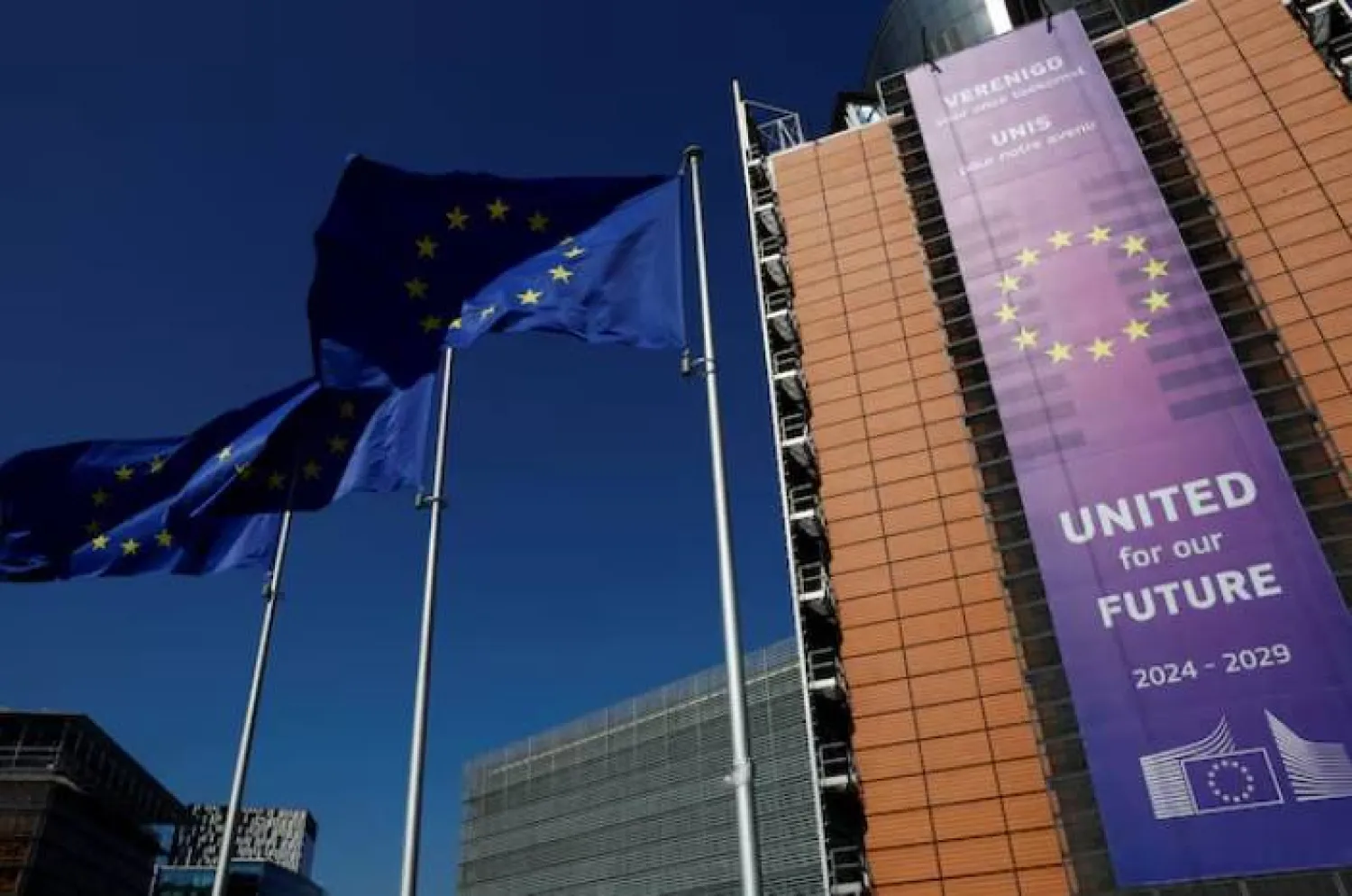 أعلام الاتحاد الأوروبي ترفرف أمام مقر المفوضية في بروكسل (رويترز)