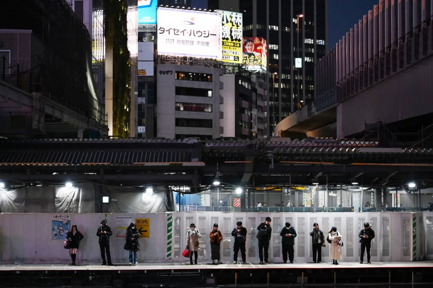 ركاب بانتظار القطار في محطة بالعاصمة اليابانية طوكيو (أ.ف.ب)