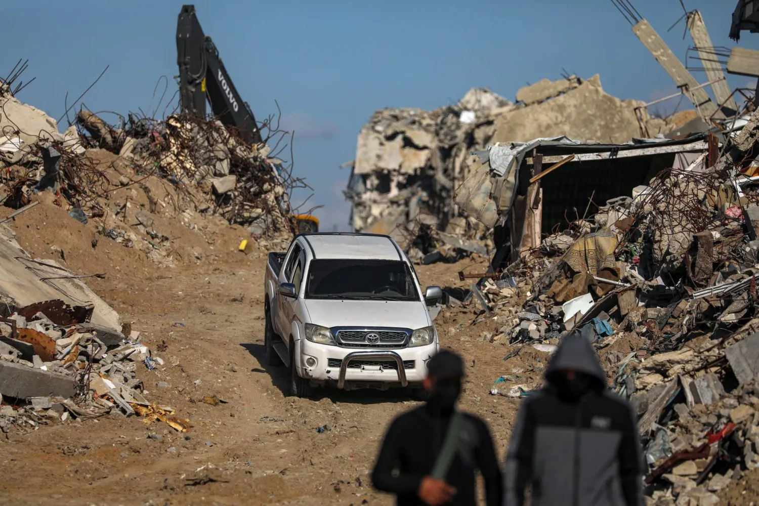 مقاتلون من «كتائب القسام» الجناح العسكري لحركة «حماس» يقفون حراساً أثناء البحث عن جثث رهائن إسرائيليين إلى جانب عمال الصليب الأحمر وسط أنقاض مخيم جباليا للاجئين شمال قطاع غزة يوم 1 ديسمبر 2025 (إ.ب.أ)