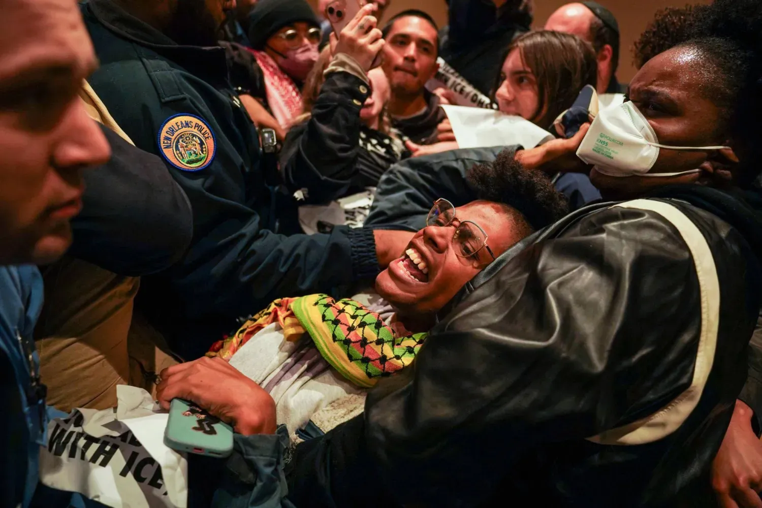 New Orleans polis memurları, şehirde federal ajanların konuşlandırılmasına karşı düzenlenen protestoya katılan bir kişiyi Belediye Binası'ndan dışarı taşıyor (AFP)