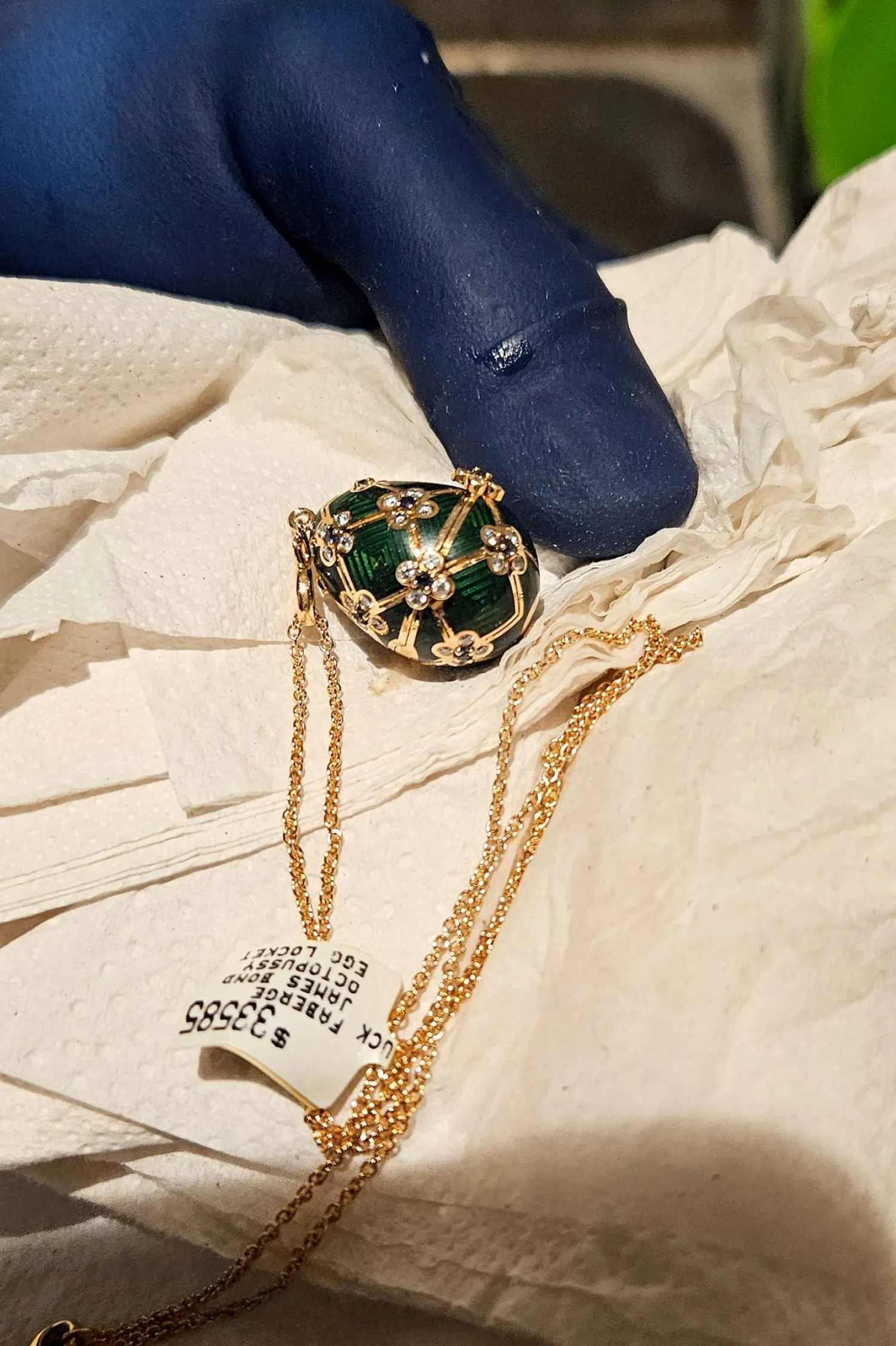 This handout photo release by New Zealand Police on December 5, 2025 shows an officer displaying a recovered diamond-encrusted green Fabergé egg in Auckland after keeping a six-day watch over the thief accused of swallowing it. (Photo by Handout / NEW ZEALAND POLICE / AFP)
