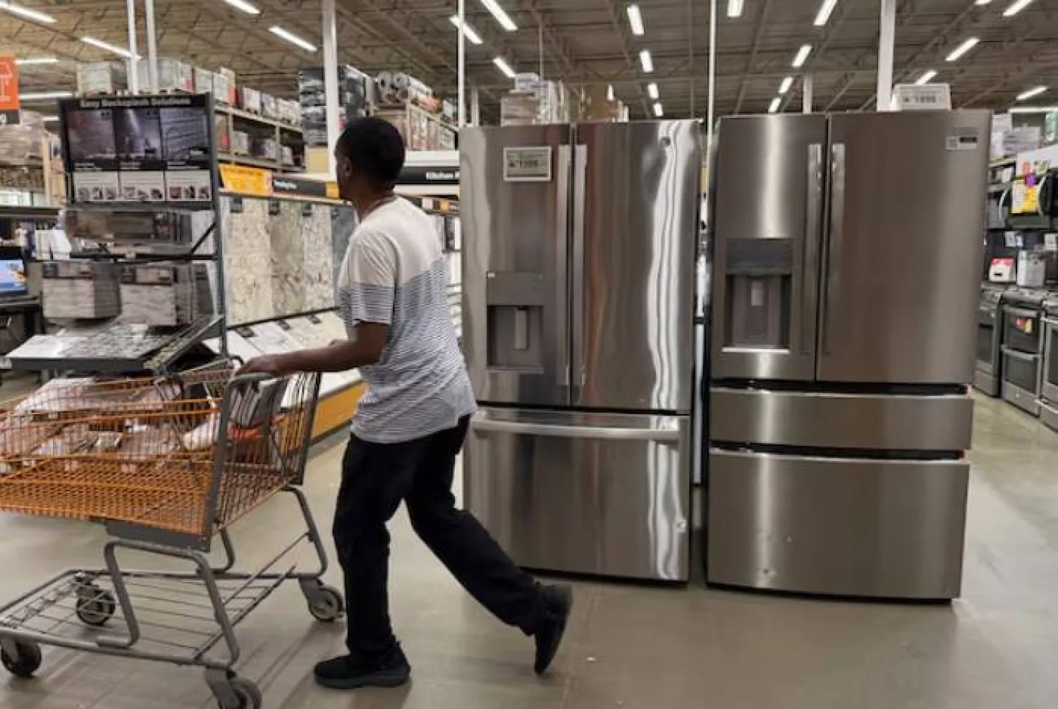 رجل يتسوق في قسم الأجهزة بمتجر هوم ديبوت في واشنطن (رويترز)