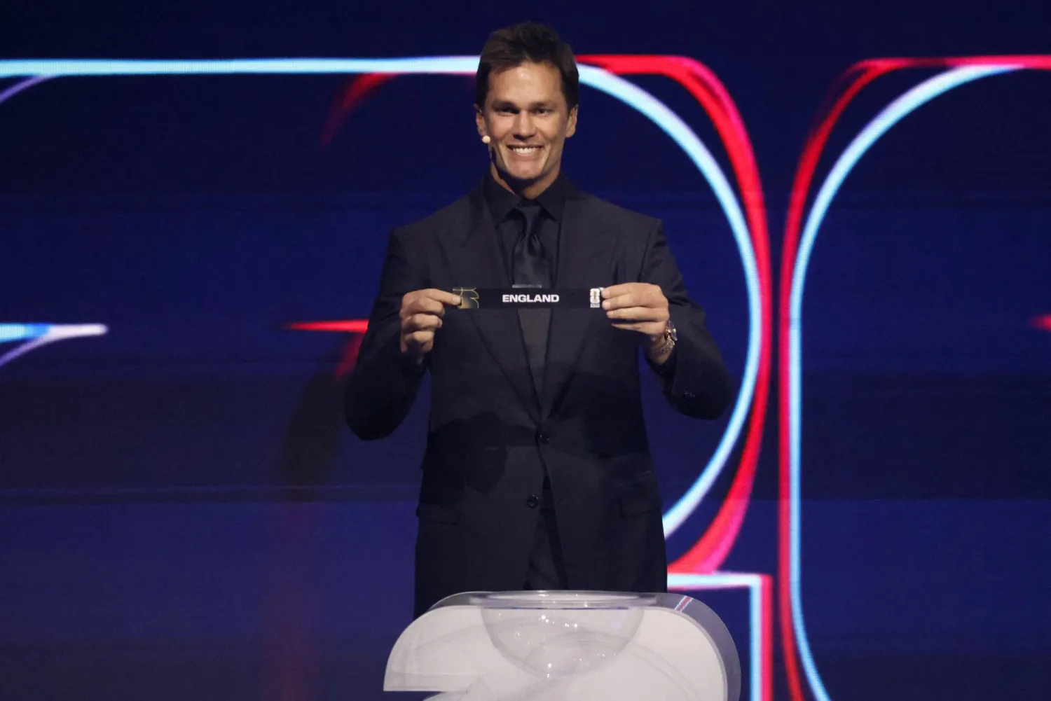 نجم كرة القدم الأميركية توم برادي عند سحبه اسم إنجلترا في قرعة المونديال (رويترز)