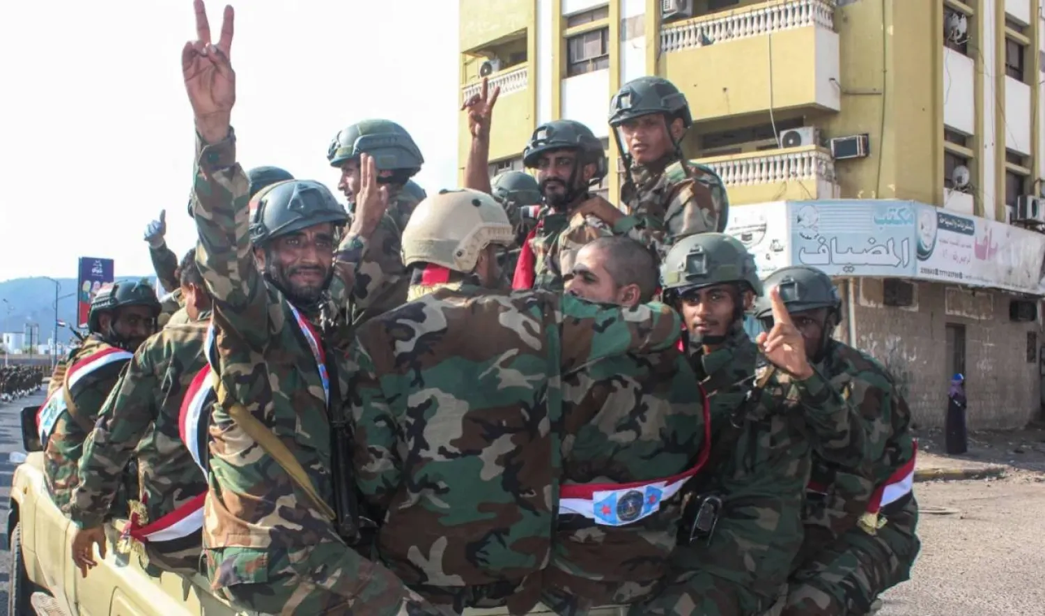 Yemeni armed forces flash the V-sign for victory as they ride in the back of a lorry as they celebrate the 58th anniversary of National Independence Day, in the port city of Aden, November 30, 2025. (Photo by Saleh Al-OBEIDI / AFP)