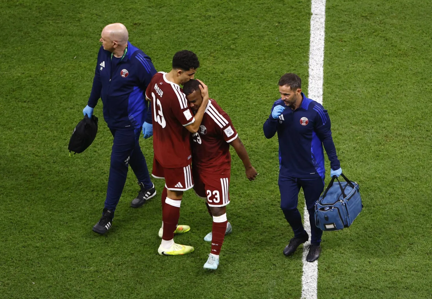 لاعب المنتخب القطري عاصم ماديبو لدى خروجه من الملعب مصاباً في مواجهة فلسطين (رويترز)