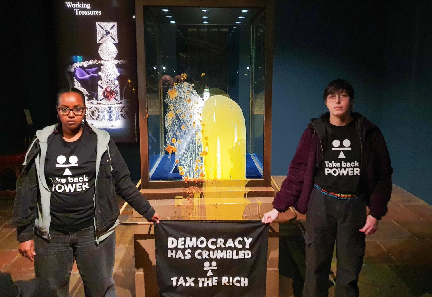 اثنان من أعضاء مجموعة تدعى «استعيدوا السلطة» لطخا صندوقاً يحتوي على تاج الدولة الإمبراطوري في لندن بفطيرة التفاح والكاسترد («استعيدوا السلطة» - أ.ف.ب)