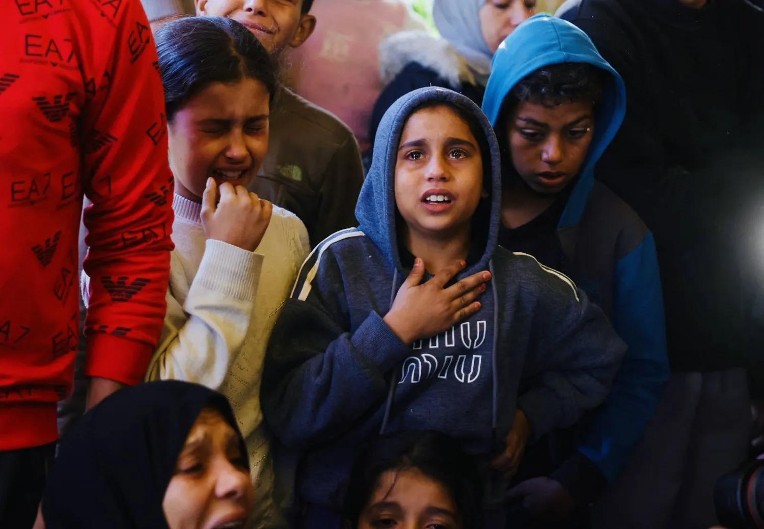 أطفال فلسطينيون يبكون خلال حضور جنازة أشخاص قُتلوا في خان يونس (أ.ف.ب)