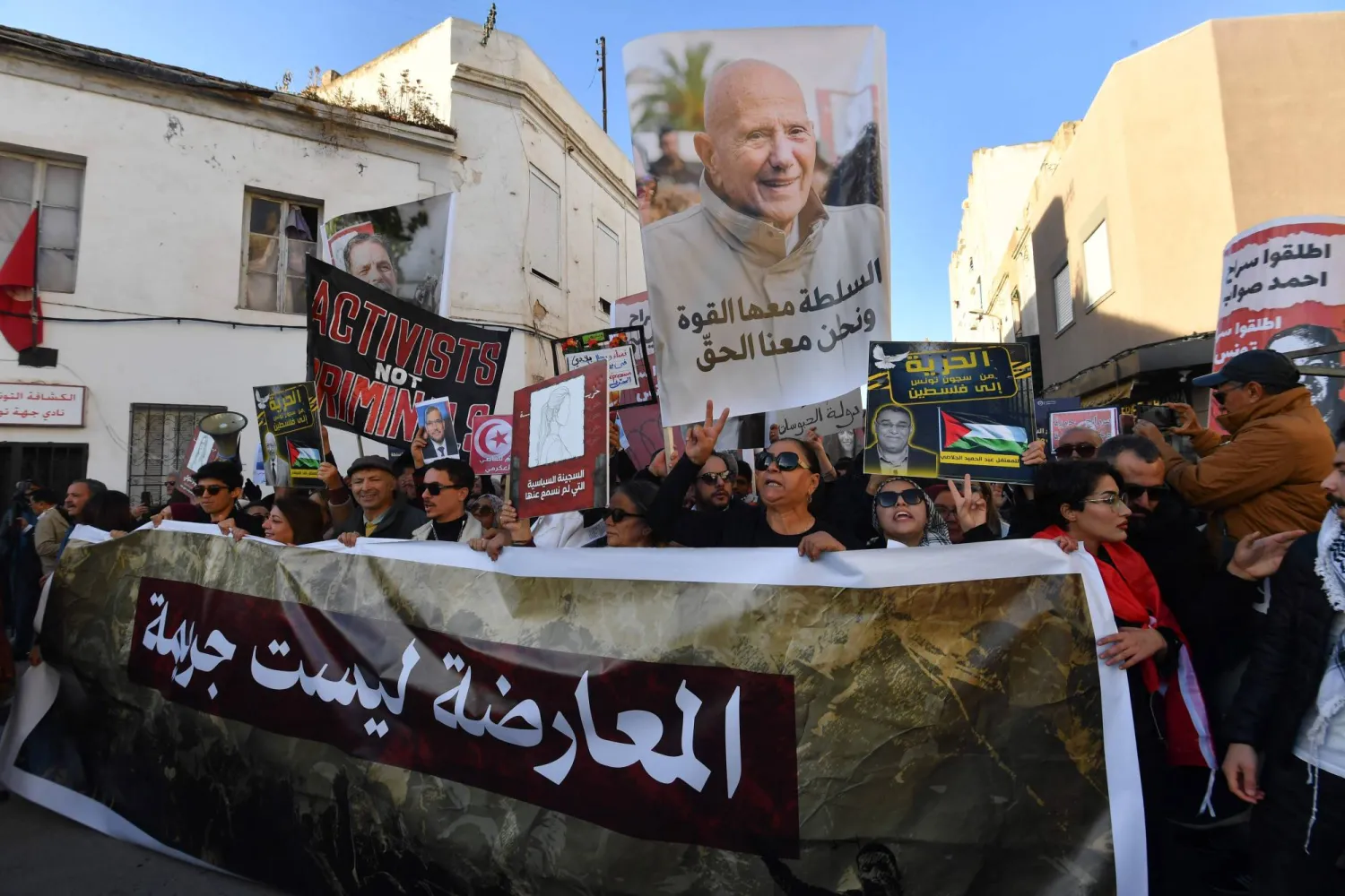 تونسيون يحملون لافتة كُتب عليها «المعارضة ليست جريمة» (أ.ف.ب) 