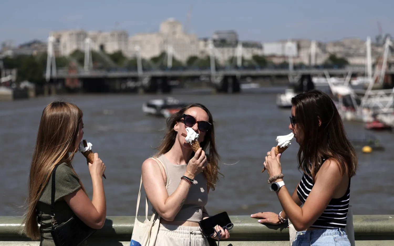 فتيات يتناولن الآيس كريم على جسر ويستمنستر في لندن (إ.ب.أ)