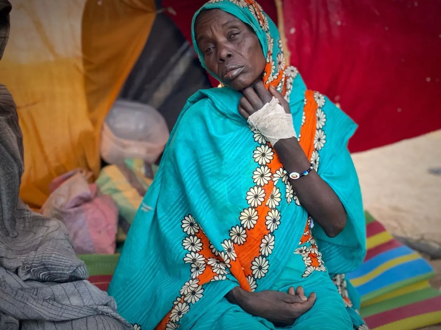 Sudan'ın Faşir kentinde çıkan çatışmada yaralanan ve Tavile Mülteci Kampı’ndaki çadırında oturan Sudanlı bir kadın (AP)