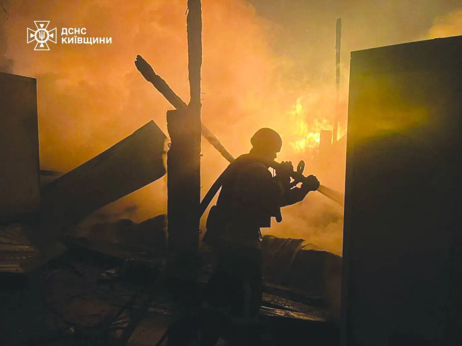 This handout photograph taken and released by the State Emergency Service of Ukraine on December 6, 2025, shows a firefighter extinguishing a fire at a site of an air attack in Kyiv region, amid the Russian invasion of Ukraine. (Photo by Handout / STATE EMERGENSY SERVICE OF UKRAINE / AFP)  