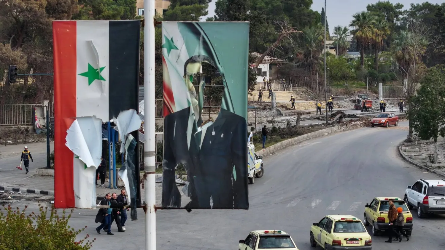 A tattered Syrian flag and Assad poster in Aleppo on Dec. 5, 2024. (AFP via Getty Images)