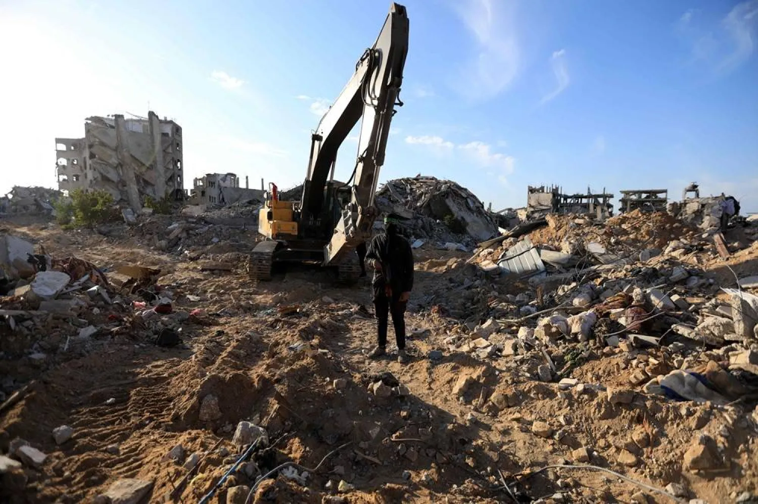 A Palestinian gunman stands guard as Hamas and Islamic Jihad fighters transport a white body bag believed to carry the remains of an Israeli hostage in the town of Beit Lahia in the northern Gaza Strip on December 3, 2025. (AFP)