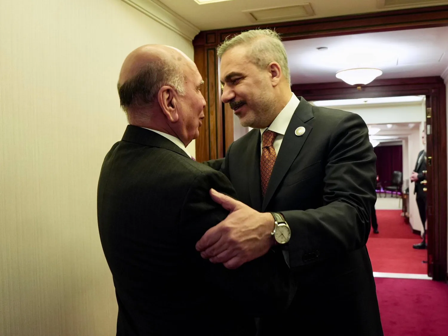 وزير الخارجية العراقي فؤاد حسين خلال مصافحة وزير الخارجية التركي هاكان فيدان على هامش منتدى الدوحة (الصفحة الرسمية لوزارة الخارجية العراقية بـ«فيسبوك»)