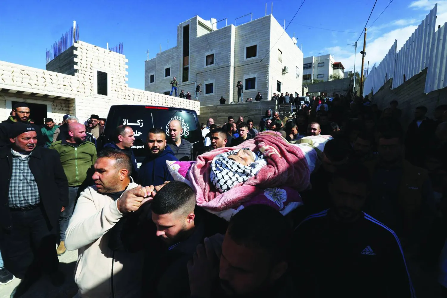 
فلسطينيون يحملون جثماناً لعامل قتلته إسرائيل في الخليل بالضفة الغربية المحتلة أمس (أ.ف.ب)