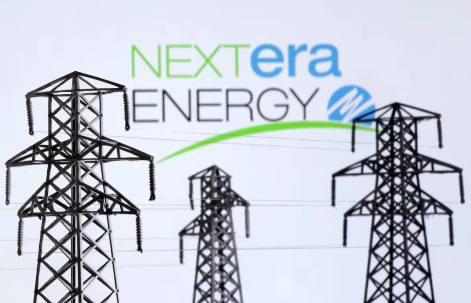 Electric power transmission pylon miniatures and Nextera Energy logo are seen in this illustration taken, December 9, 2022. REUTERS/Dado Ruvic/Illustration 