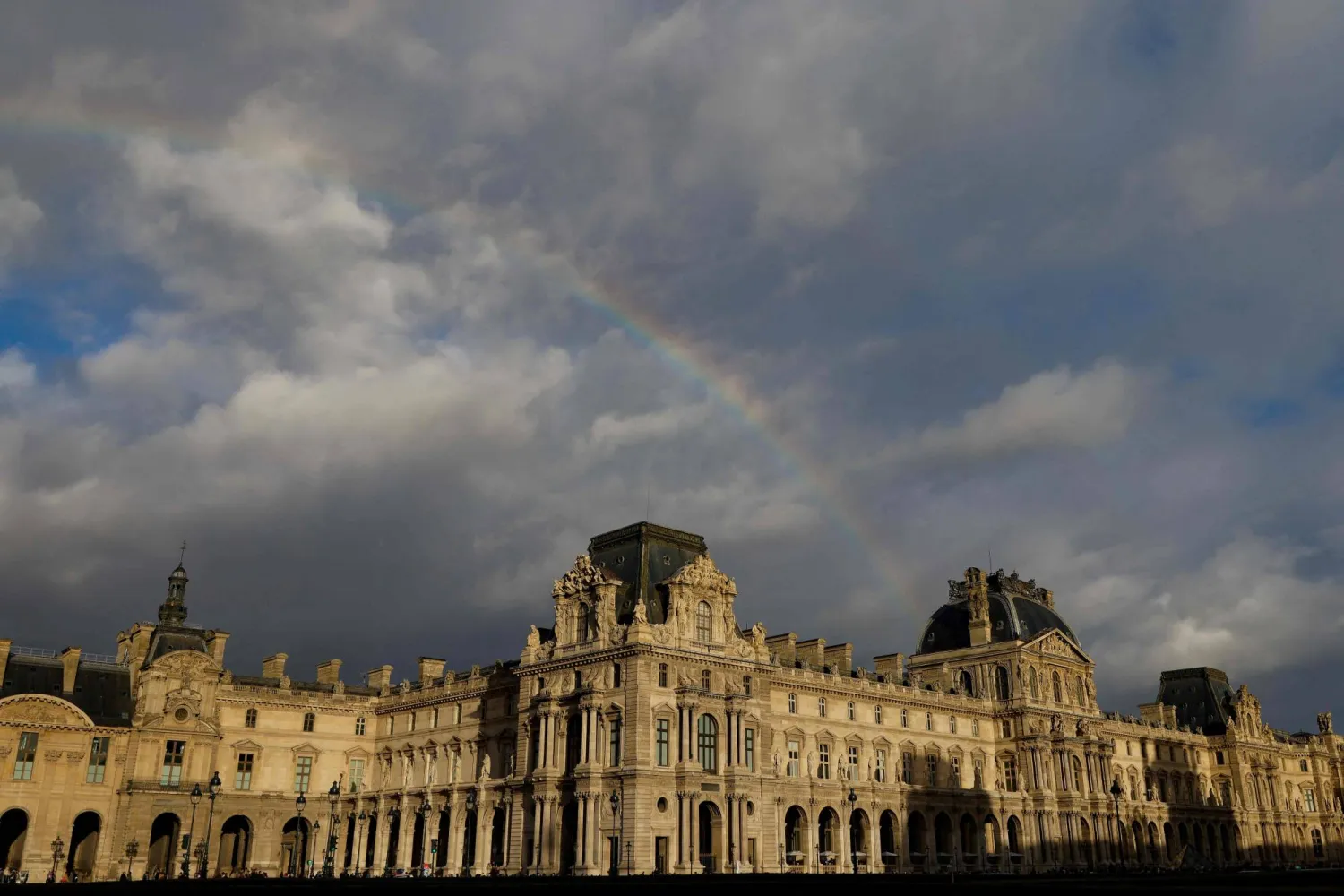 A rainbow emerges over the Louvre museum, bathed in late afternoon sunlight, in Paris, on December 6, 2025. (AFP)