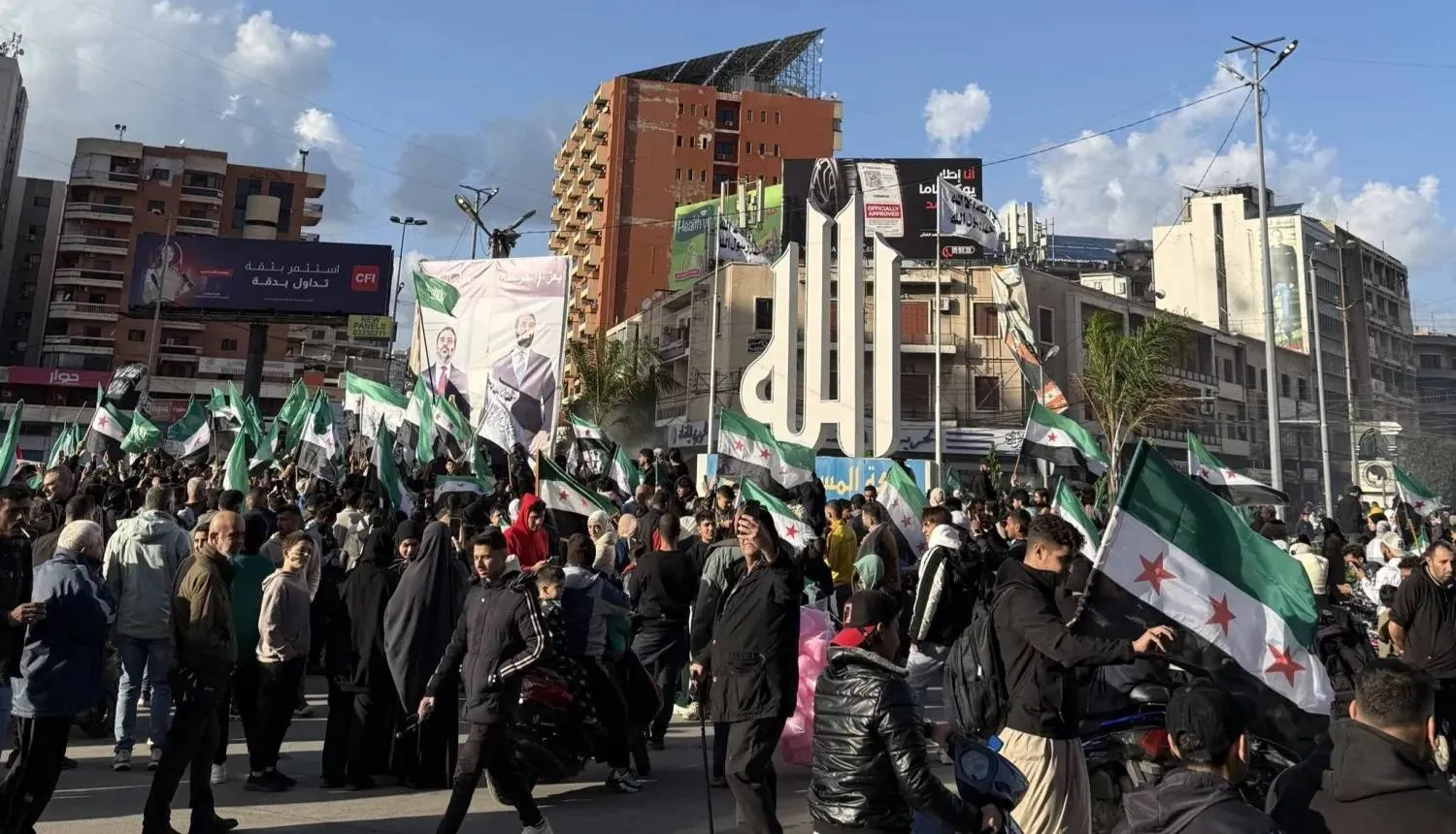People raise the Syrian flag during the one-year anniversary marking the ouster of Bashar al-Assad in Tripoli, Lebanon.  