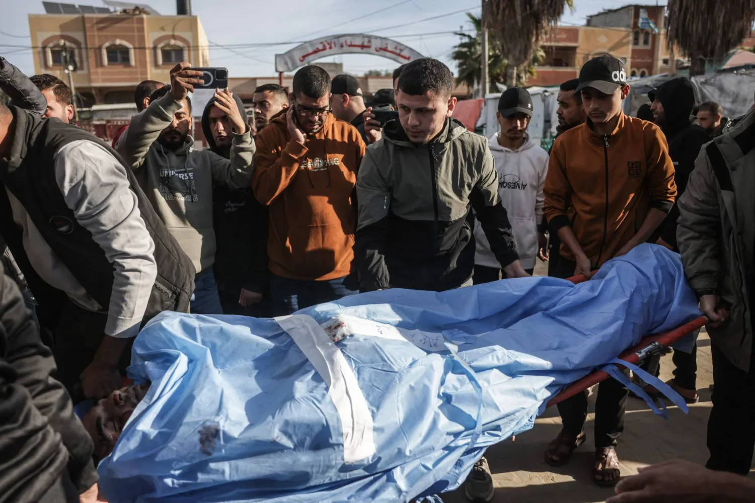 أصدقاء وأقارب للفلسطيني الراحل محمد الجرو يحملون جثمانه خلال جنازته داخل دير البلح يوم 9 ديسمبر 2025 بعد استشهاده في غارة جوية إسرائيلية (أ.ف.ب)