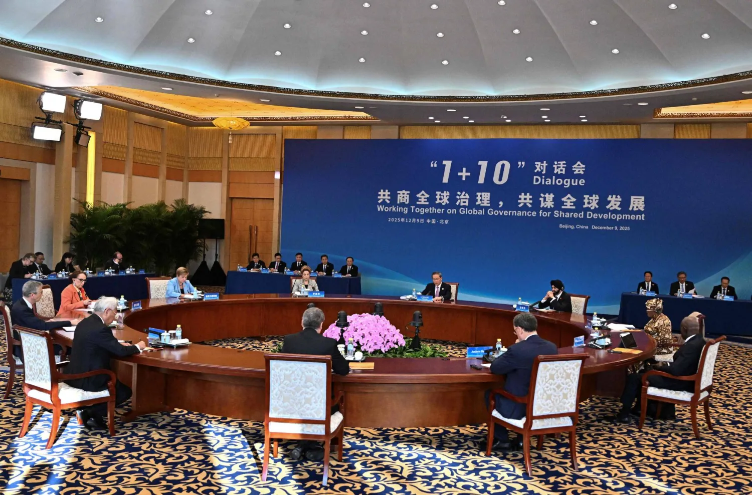 رئيس الوزراء الصيني ومديرو المؤسسات الدولية خلال اجتماع «1+10» في العاصمة بكين (أ.ف.ب)