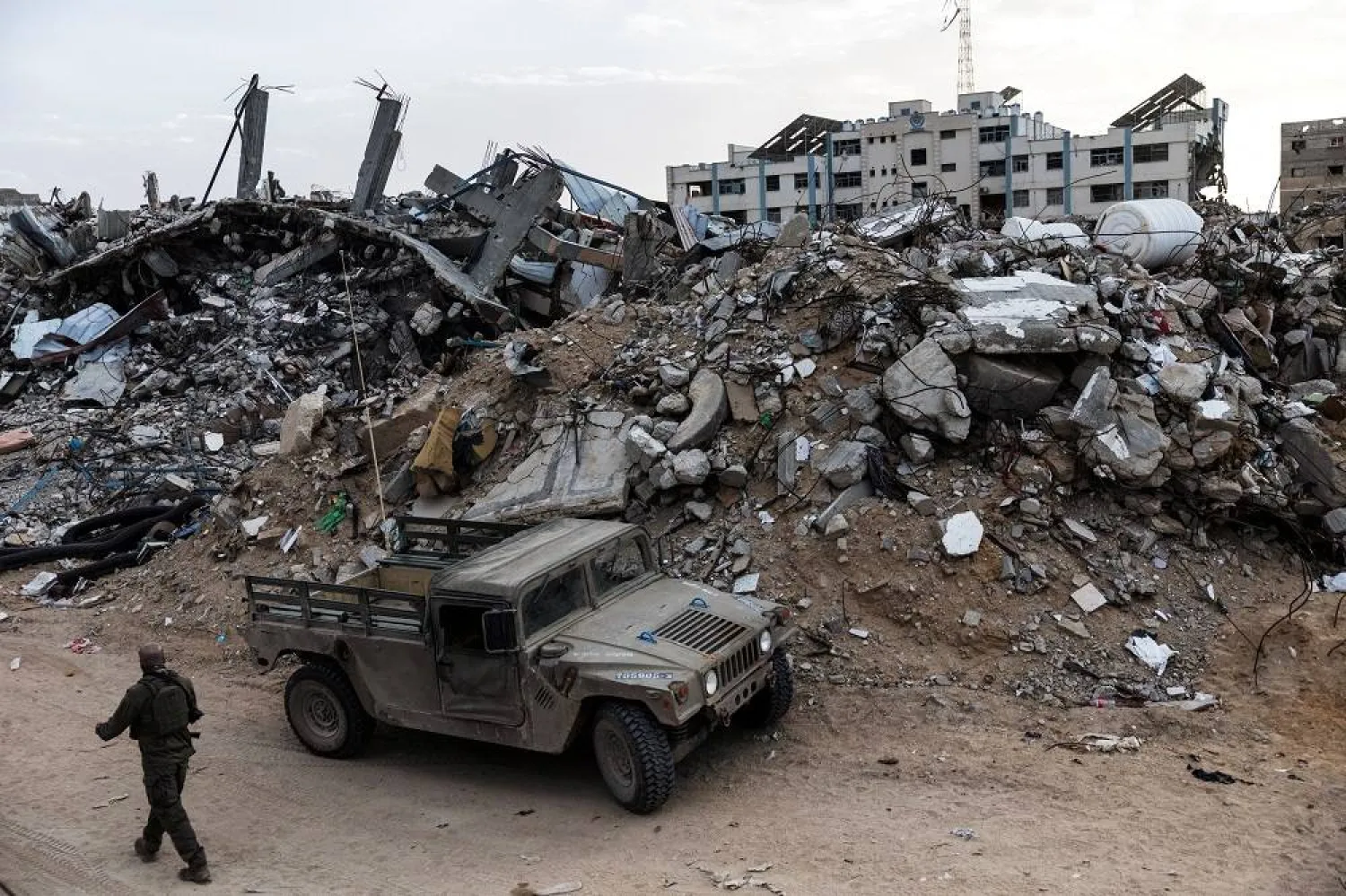 An Israeli soldier walks past a military vehicle and rubble in Rafah in the southern Gaza Strip, December 8, 2025. (Reuters)