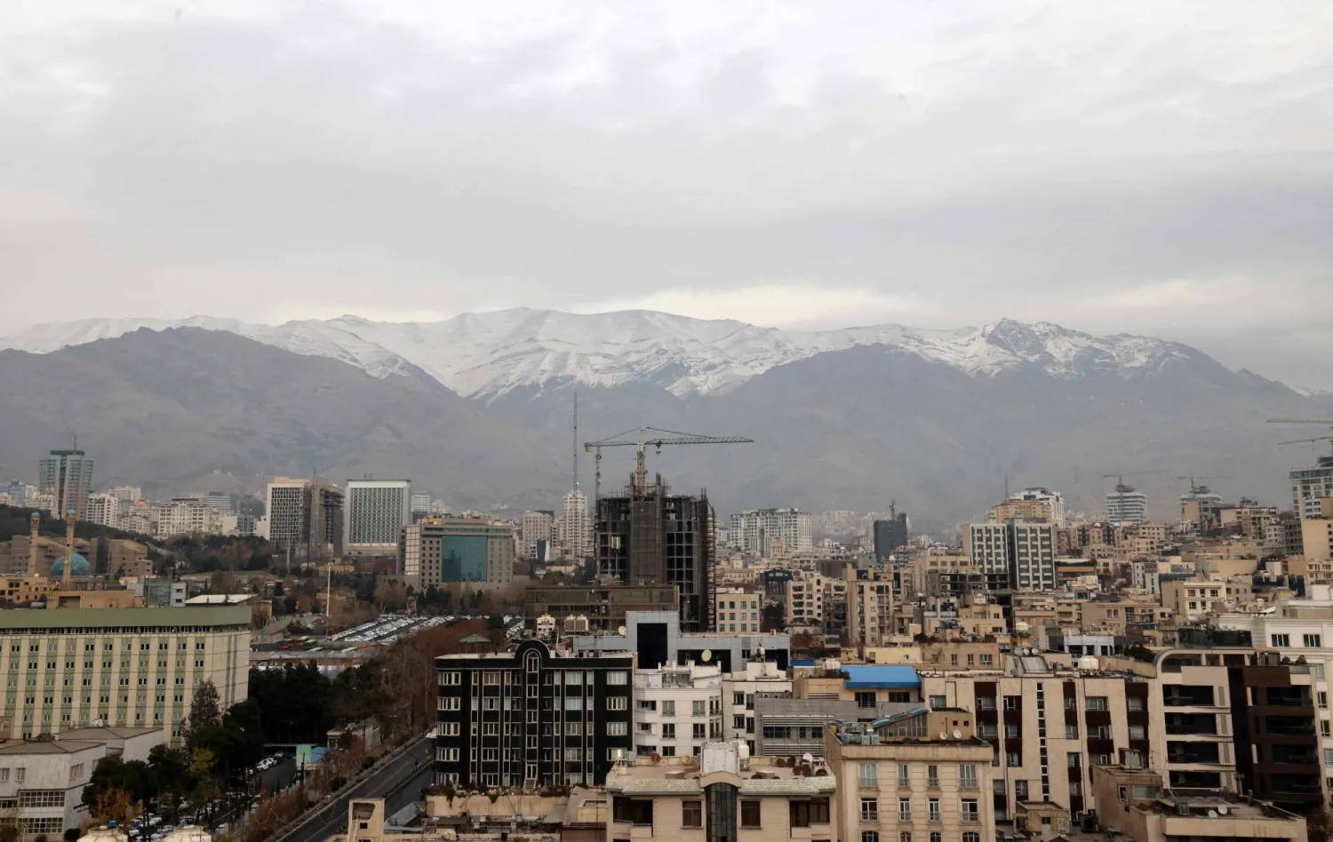A general view shows the Iranian capital Tehran with the snow-covered Alborz mountain range in the background on December 9, 2025, after a year of drought and water shortage in Iran. (AFP)