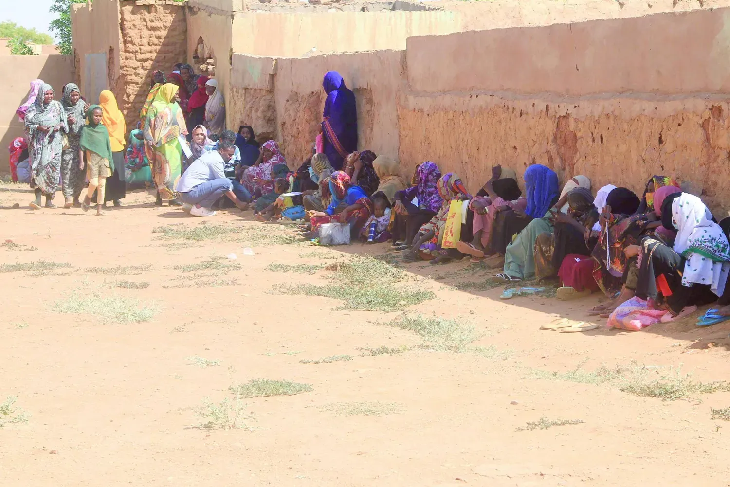 Geçtiğimiz kasım ayında Kuzey Kordofan'dan gelen yerinden edilmiş kişiler, Omdurman şehrinde bir duvarın gölgesinde oturuyor. (AFP)