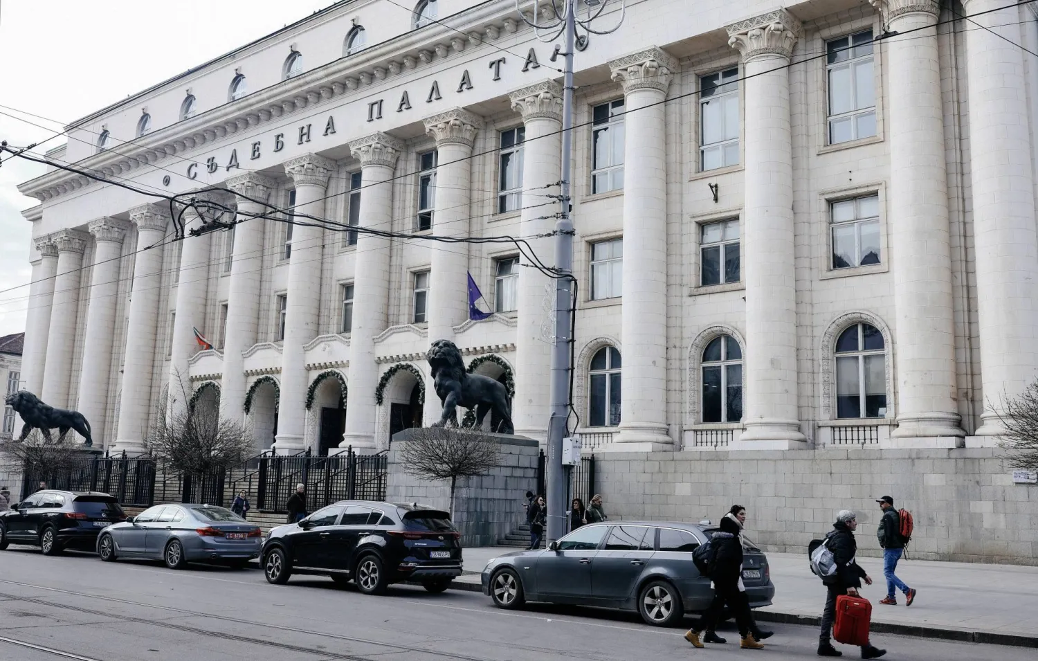 يمر الناس أمام محكمة مدينة صوفيا حيث تُعقد جلسة استماع لتسليم إيغور غريتشوشكين وهو مواطن روسي والمالك المزعوم لسفينة الشحن «إم في روسوس» في بلغاريا (إ.ب.أ)