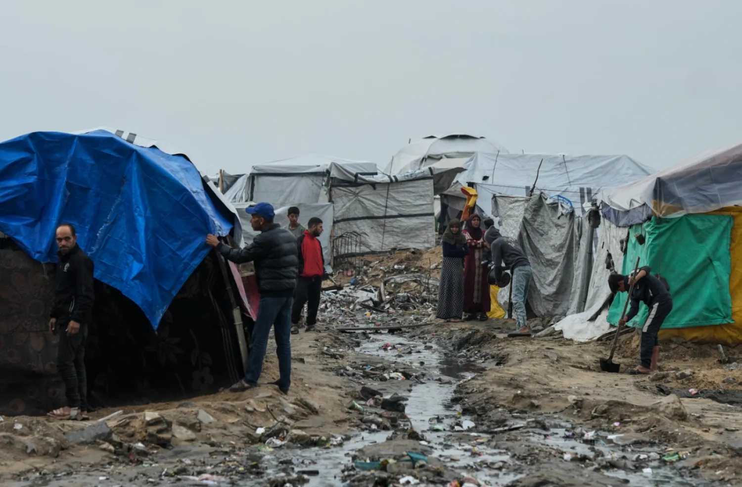 Displaced Palestinians repair their tents at a tent camp on the beach after a stormy weather in Gaza City, Wednesday, Dec. 10, 2025. (AP Photo/Jehad Alshrafi)