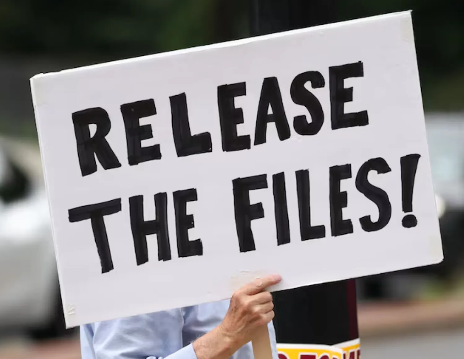 A protester calling for a release of the Epstein files holds a sign while awaiting the arrival of Trump administration officials who are expected to discuss strategy amid the deepening political crisis over the administration’s handling of files related to convicted sex offender Jeffrey Epstein, at the US Naval Observatory - Reuters