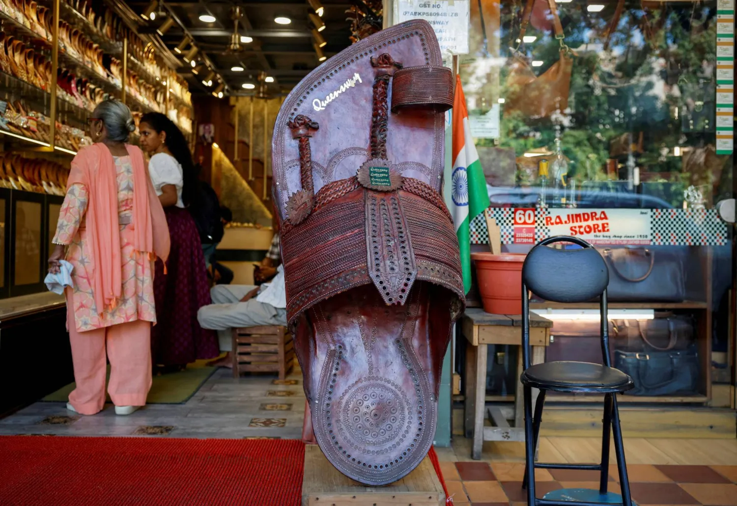 FILE PHOTO: Customers shop for 'Kolhapuri' sandals, an Indian ethnic footwear, at a store in New Delhi, India, June 27, 2025. REUTERS/Adnan Abidi/File Photo