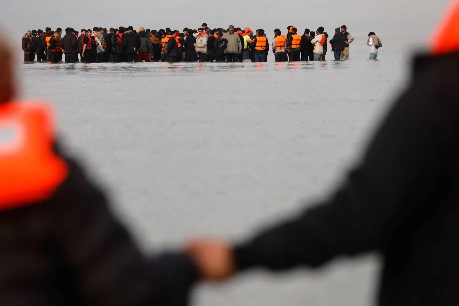 FILE - Migrants push a small boat in an attempt to reach Britain, Thursday, Nov. 6, 2025 in Gravelines, northern France. (AP Photo/Jean-Francois Badias, file)