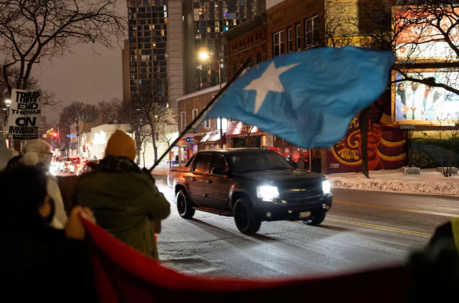 A demonstrator waves a flag of Somalia as a vehicle passes by a rally in protest against Immigration and Customs Enforcement (ICE), amid a reported federal immigration operation targeting the Somali community, in Minneapolis, Minnesota, US December 8, 2025. REUTERS/Tim Evans/File Photo 