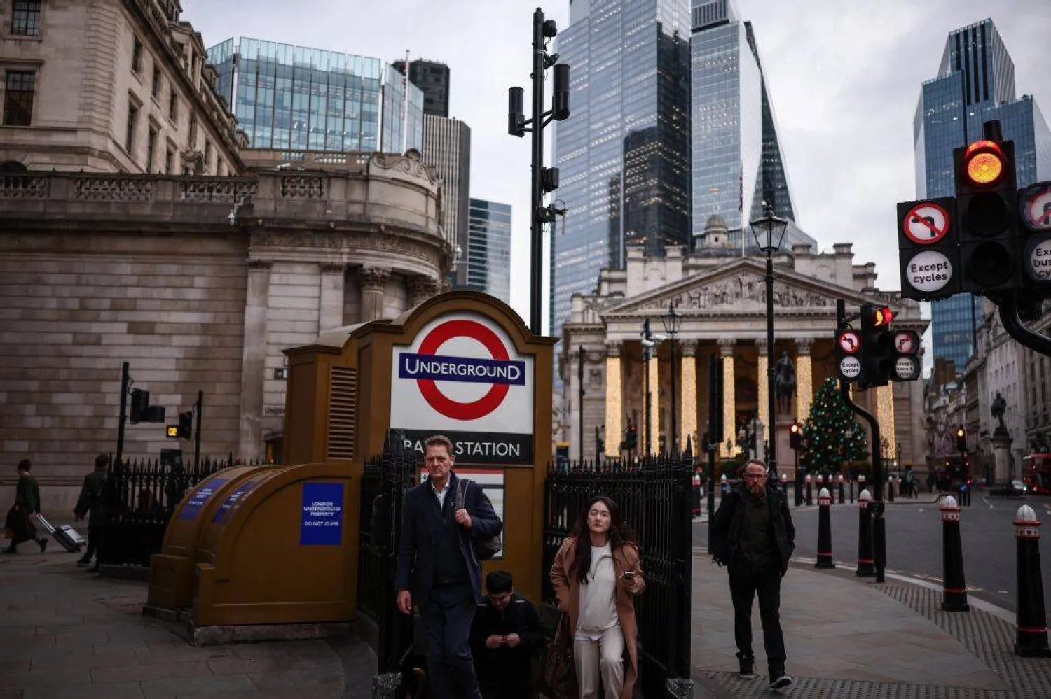 People exit the London Underground station at Bank, outside the Bank of England (L) and the Royal Exchange building (back R) in central London on December 12, 2025. (Photo by HENRY NICHOLLS / AFP)