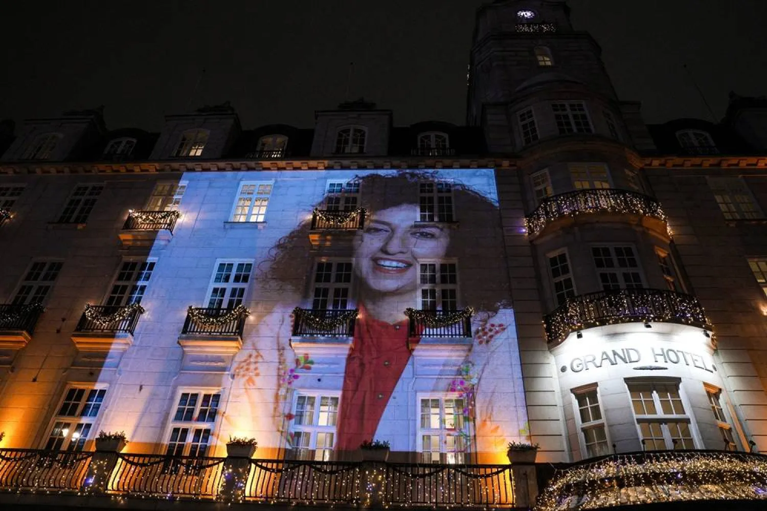 A picture of the 2023 Nobel Peace Prize winner Narges Mohammadi is projected on the facade of the Grand Hotel before the Nobel Banquet in Oslo, Norway, 10 December 2023. (EPA)