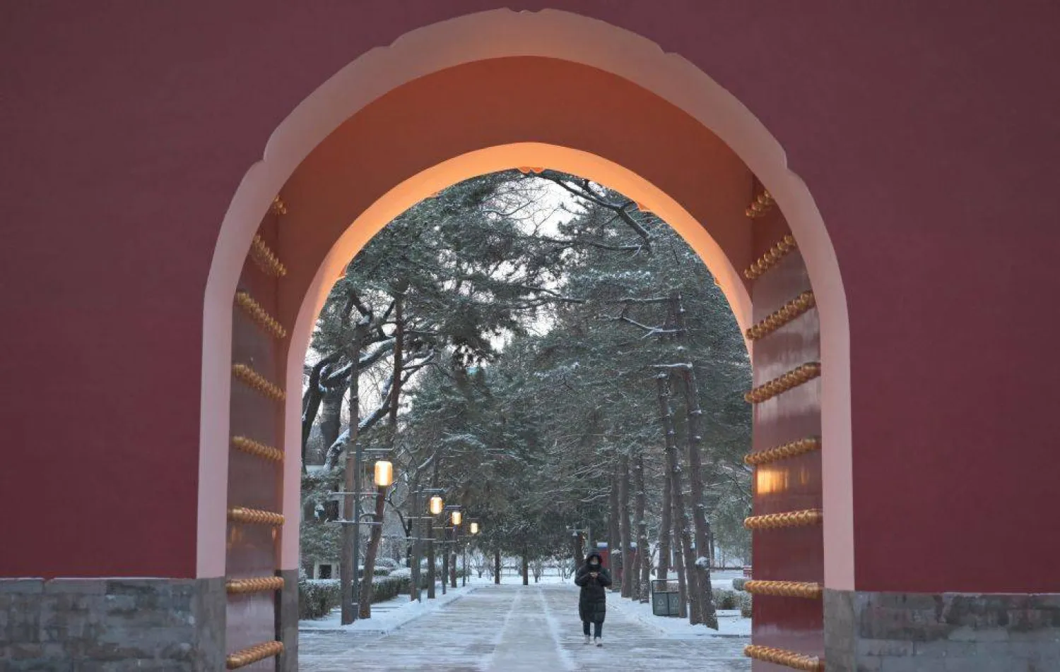 A woman walks in Ritan park one day after a heavy snowfall in Beijing on December 13, 2025. (AFP)