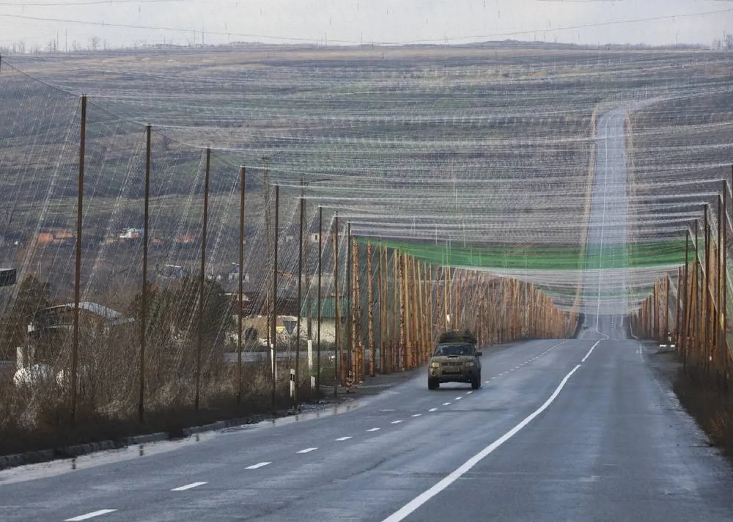 Anti-drone nets hang taut along a road near the city of Izyum of Kharkiv region, northeastern Ukraine, 12 December 2025. (EPA)