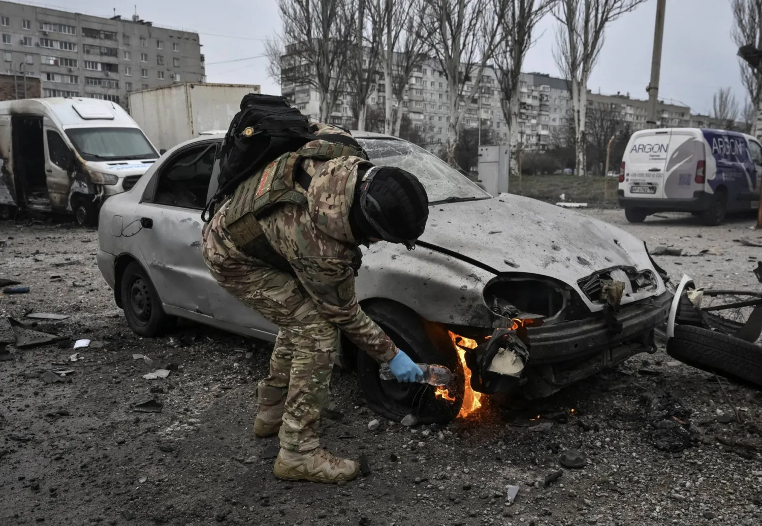 ضابط شرطة يُطفئ سيارة محترقة في موقع غارة جوية روسية بطائرة مسيَّرة وسط الهجوم على أوكرانيا في زابوروجيا (رويترز)