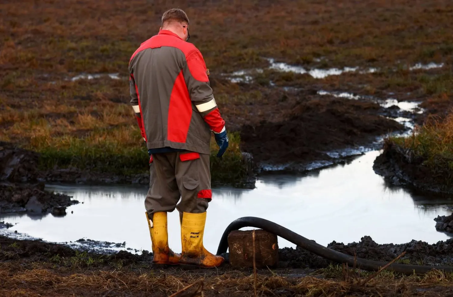 عامل يتابع سحب النفط المسرب للمياه من خط أنابيب بالقرب من جرامتسوف بألمانيا 11 ديسمبر 2025 (رويترز)