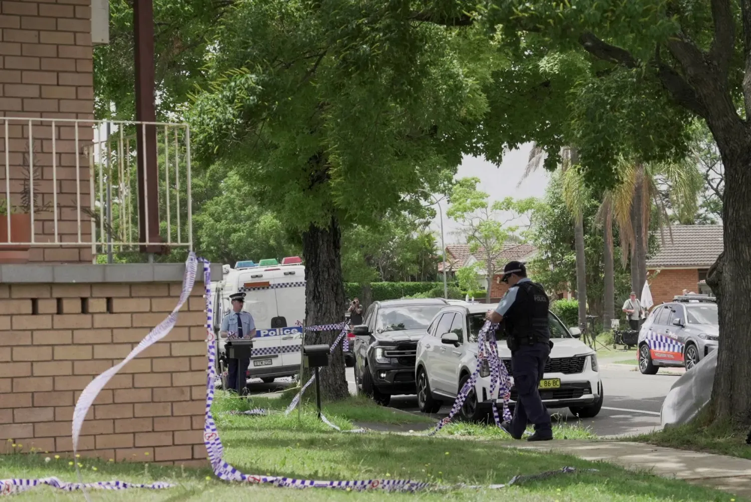 Bondi Plajı saldırısının şüphelisinin evini çevreleyen şeridi kaldıran Avustralyalı bir polis memuru (Reuters)