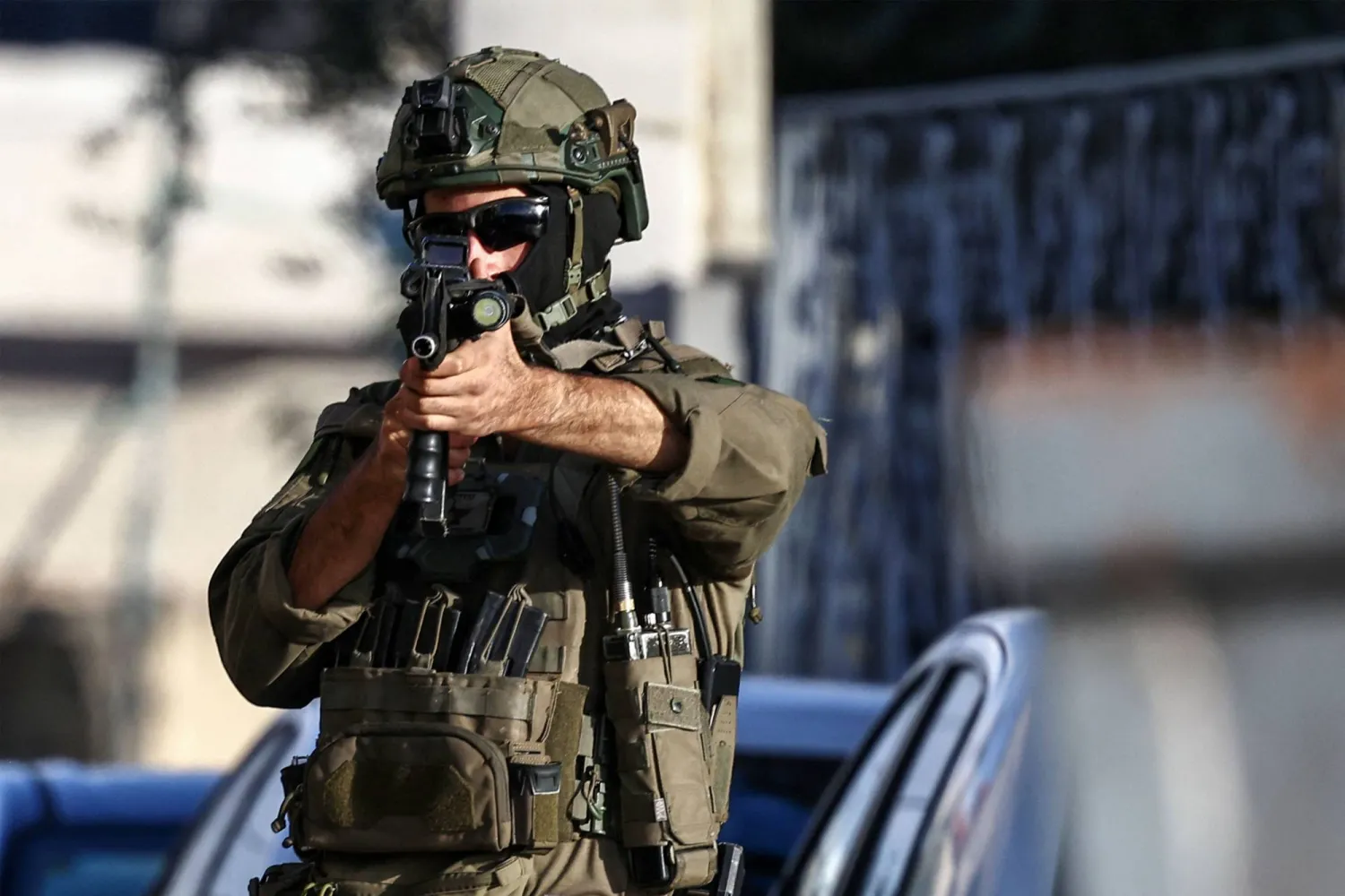 جندي إسرائيلي يصوّب سلاحه خلال دورية في رام الله (أ.ف.ب)