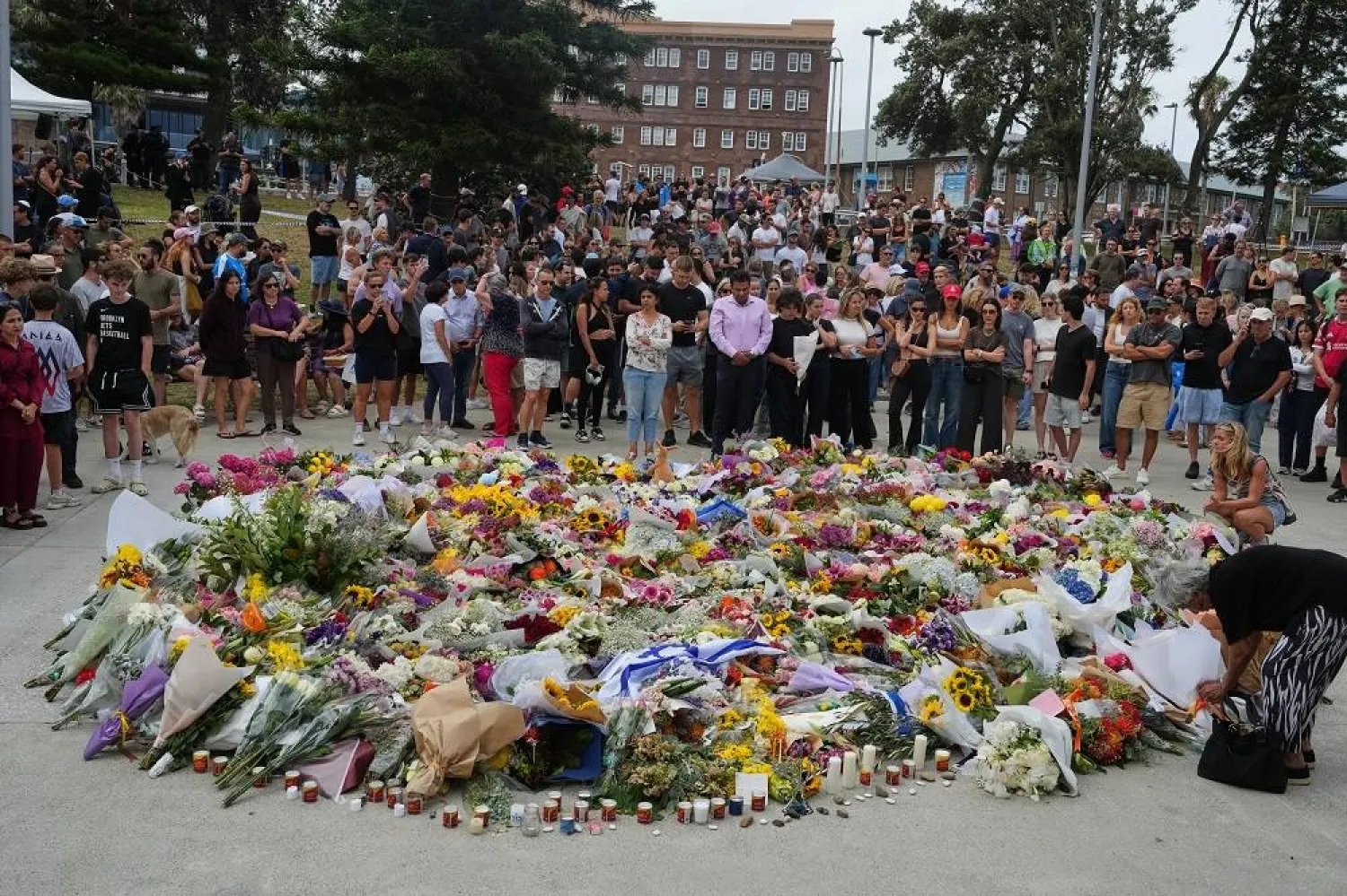 People gather around a tribute for shooting victims outside the Bondi Pavilion at Sydney's Bondi Beach, Monday, Dec. 15, 2025, a day after a shooting. (AP)