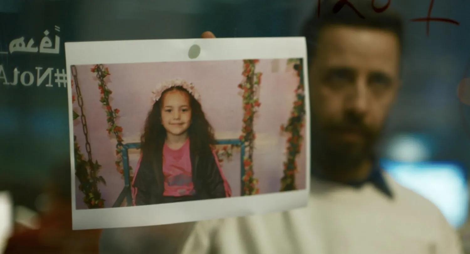 الممثل معتز ملحيس وأمامه صورة الطفلة هند رجب في مشهد من الفيلم (أ.م.د.ب)