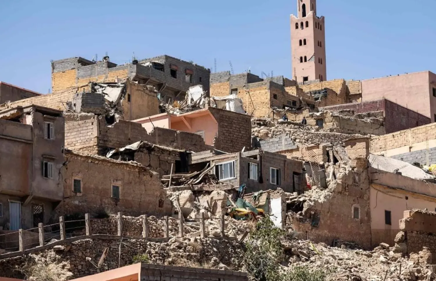 The minaret of a mosque stands behind damaged or destroyed houses following an earthquake in Moulay Brahim, Al-Haouz province, on September 9, 2023. (AFP)

