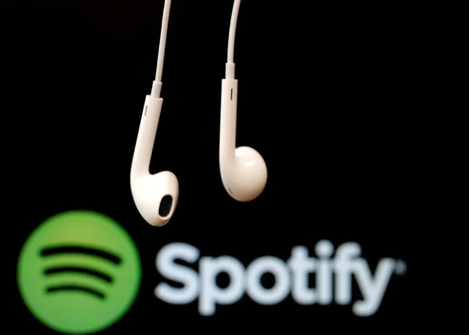 FILE PHOTO: Headphones are seen in front of a logo of online music streaming service Spotify, February 18, 2014 REUTERS/Christian Hartmann/File Photo
