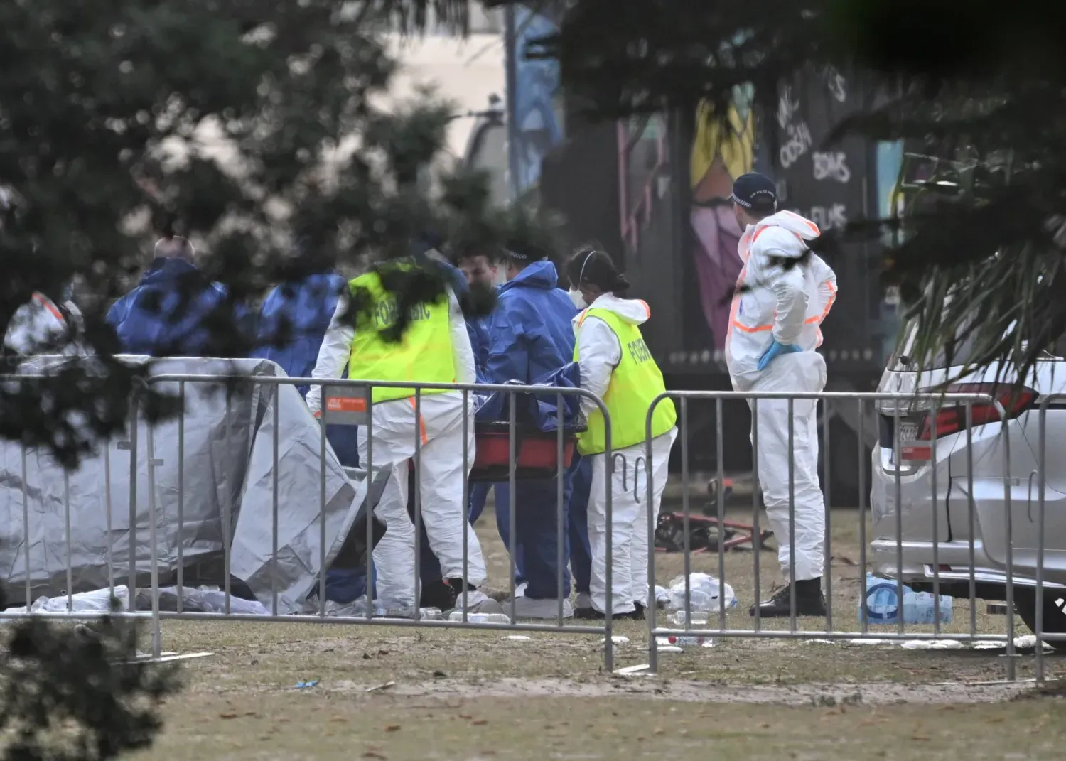 Adli tıp uzmanları, Sidney'deki Bondi Plajı'nda meydana gelen silahlı saldırı olay yerinde kurbanlardan birinin cesedini inceliyor (EPA)