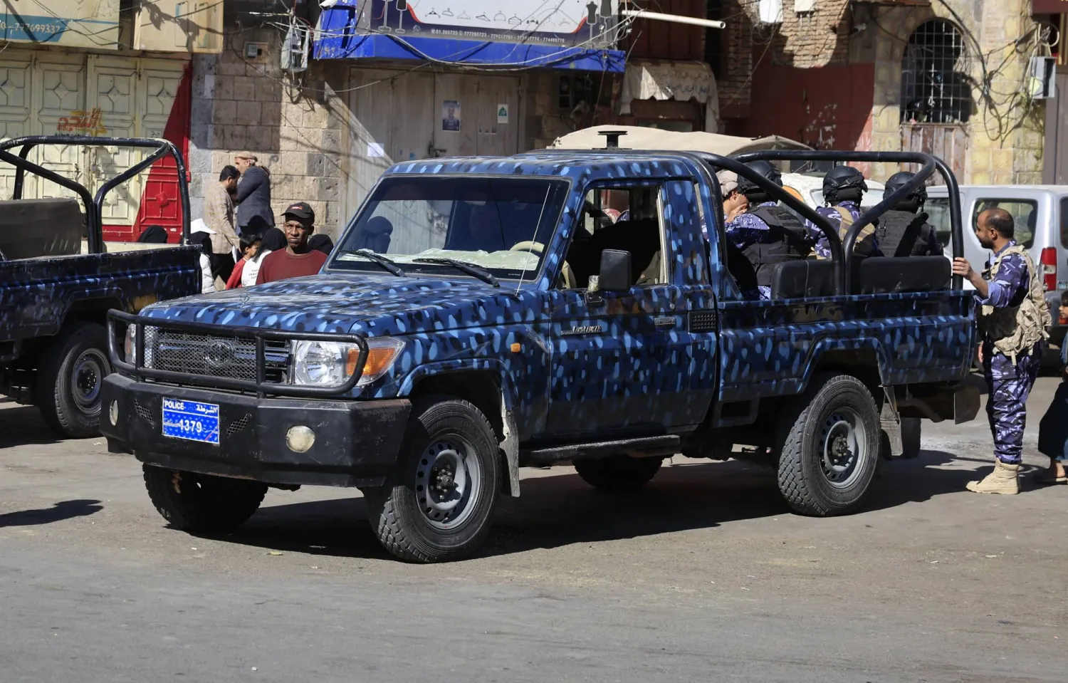 مسلحون حوثيون على متن عربة أمنية في أحد شوارع العاصمة اليمنية المختطفة صنعاء (إ.ب.أ)