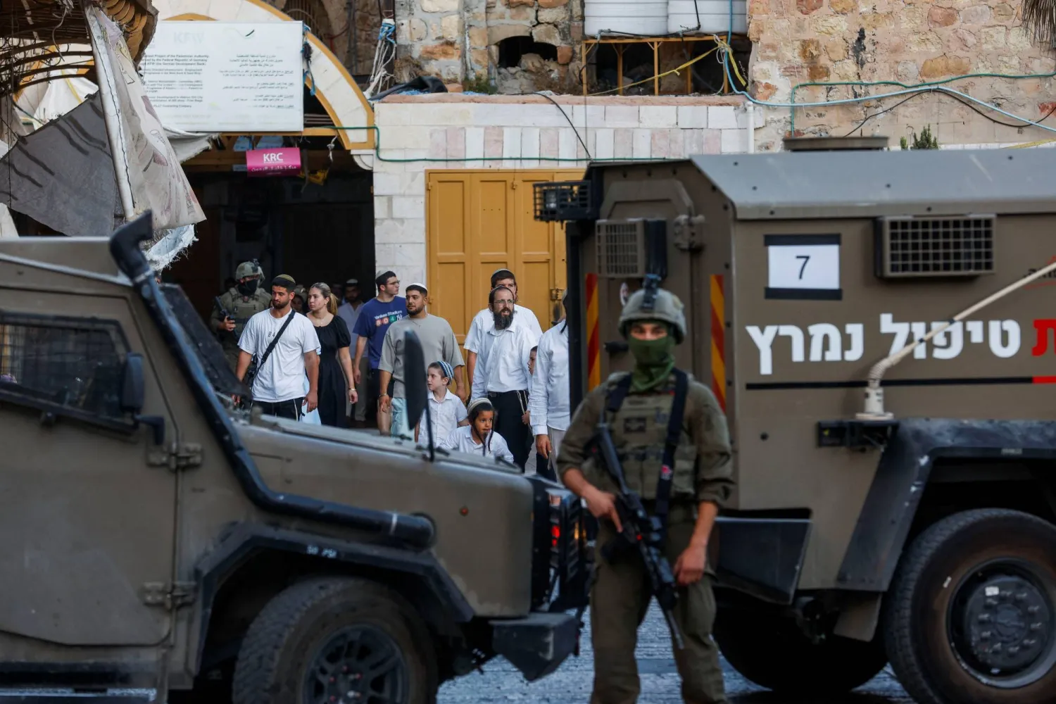 جندي إسرائيلي يقف لحماية المشاركين في جولة أسبوعية للمستوطنين في الخليل بالضفة الغربية المحتلة (أرشيفية - رويترز)